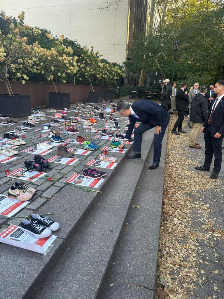 Множество пар обуви, выложенных в знак памяти о жертвах ХАМАС возле здания ООН
